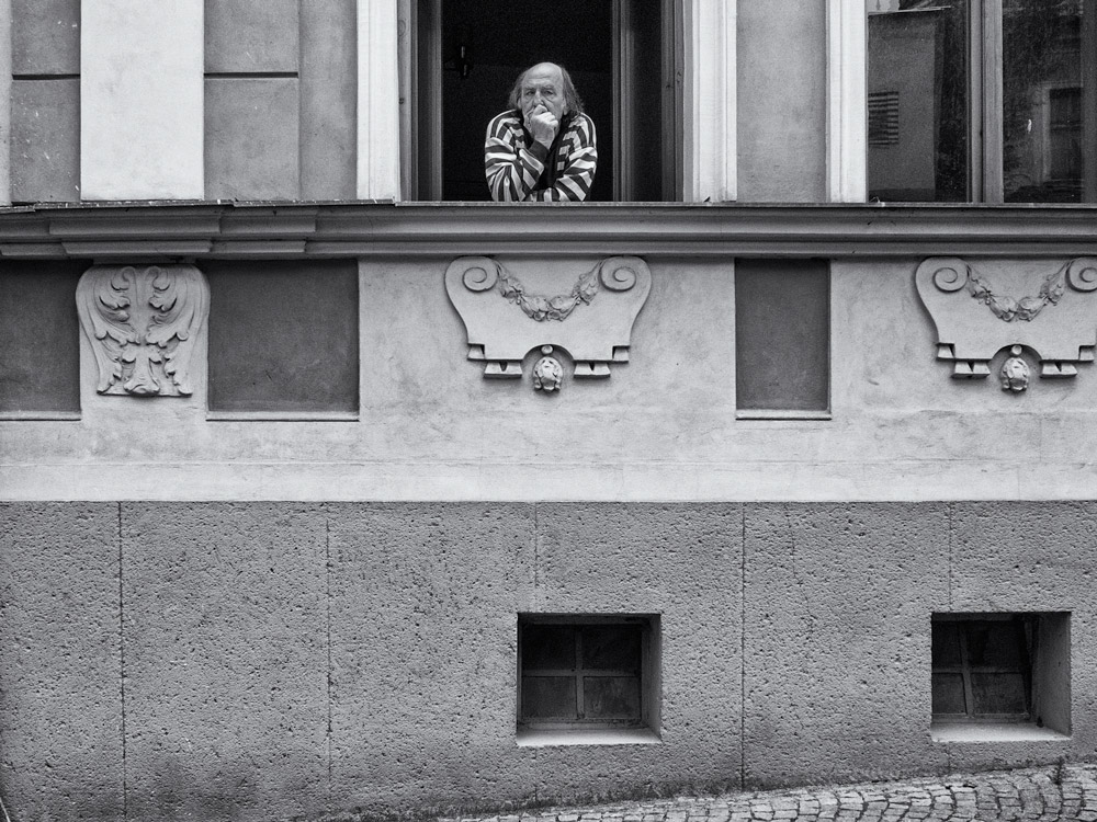 View of an old man looking out from a window in Kutna Hora, Czech Republic