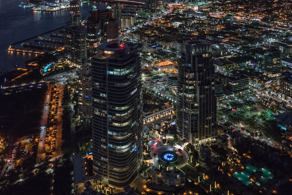 Downtown Miami seen from a helicopter. Downtown Miami buildings and streets lit at night.