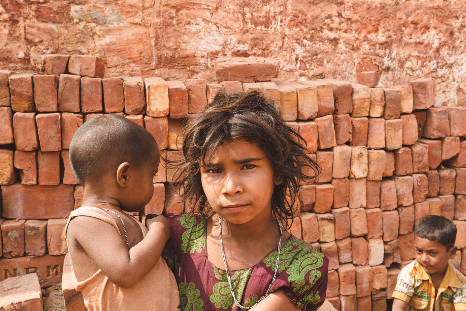 Chittagong, Bangladesh brick worker children caring for the younger sibling.