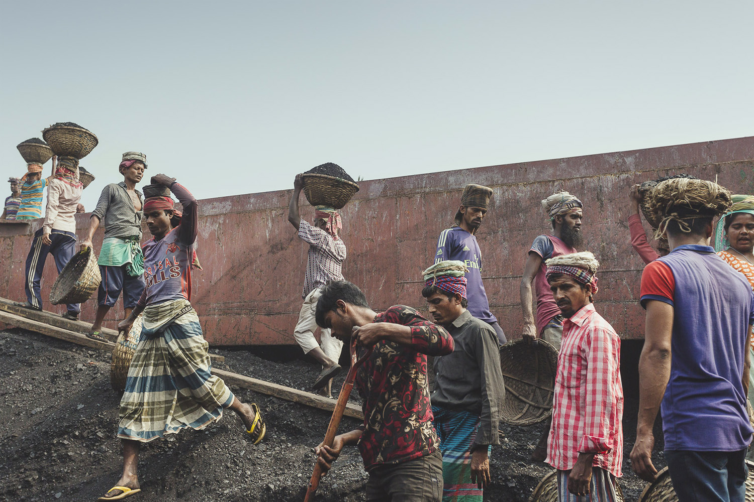 The coal workers at Dhaka, Bangladesh are consistently walking back and forth with loads of coal on their heads.