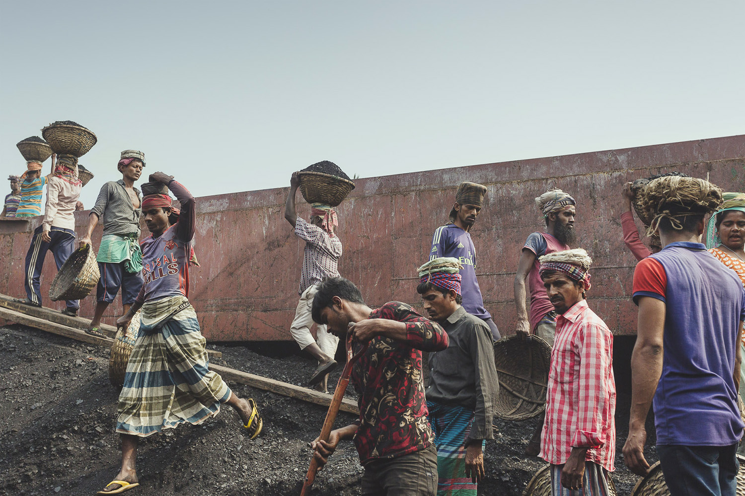 The coal workers at Dhaka, Bangladesh are consistently walking up and down with loads of coal on their heads.