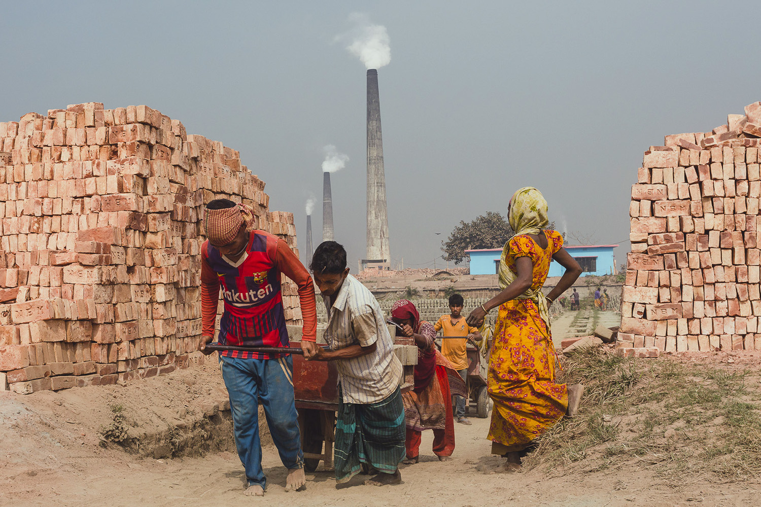 Heavy loads of bricks being pulled up hill by teamwork at the Chittagong, Bangladesh facility.