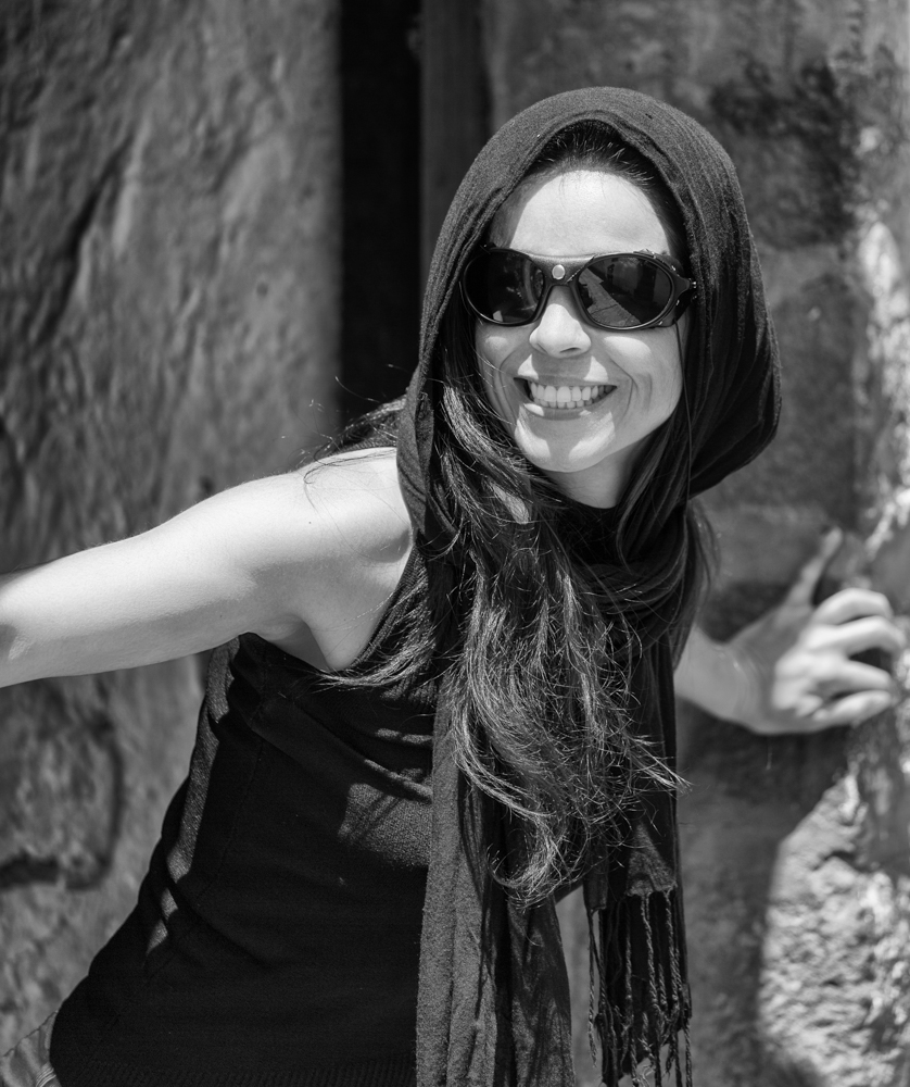 Portrait with natural light of a woman looking out of her door greeting visitors. Black and white portrait.