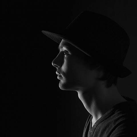 Rim lighting with male model. Black and white portrait.  Minimalist studio lighting and model . Low key portrait.