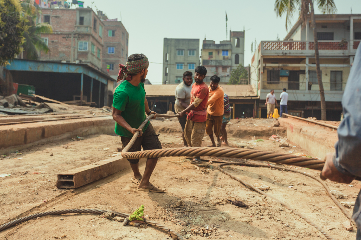 Team of men working to move cables at Dhaka, Bangladesh Shipyard.