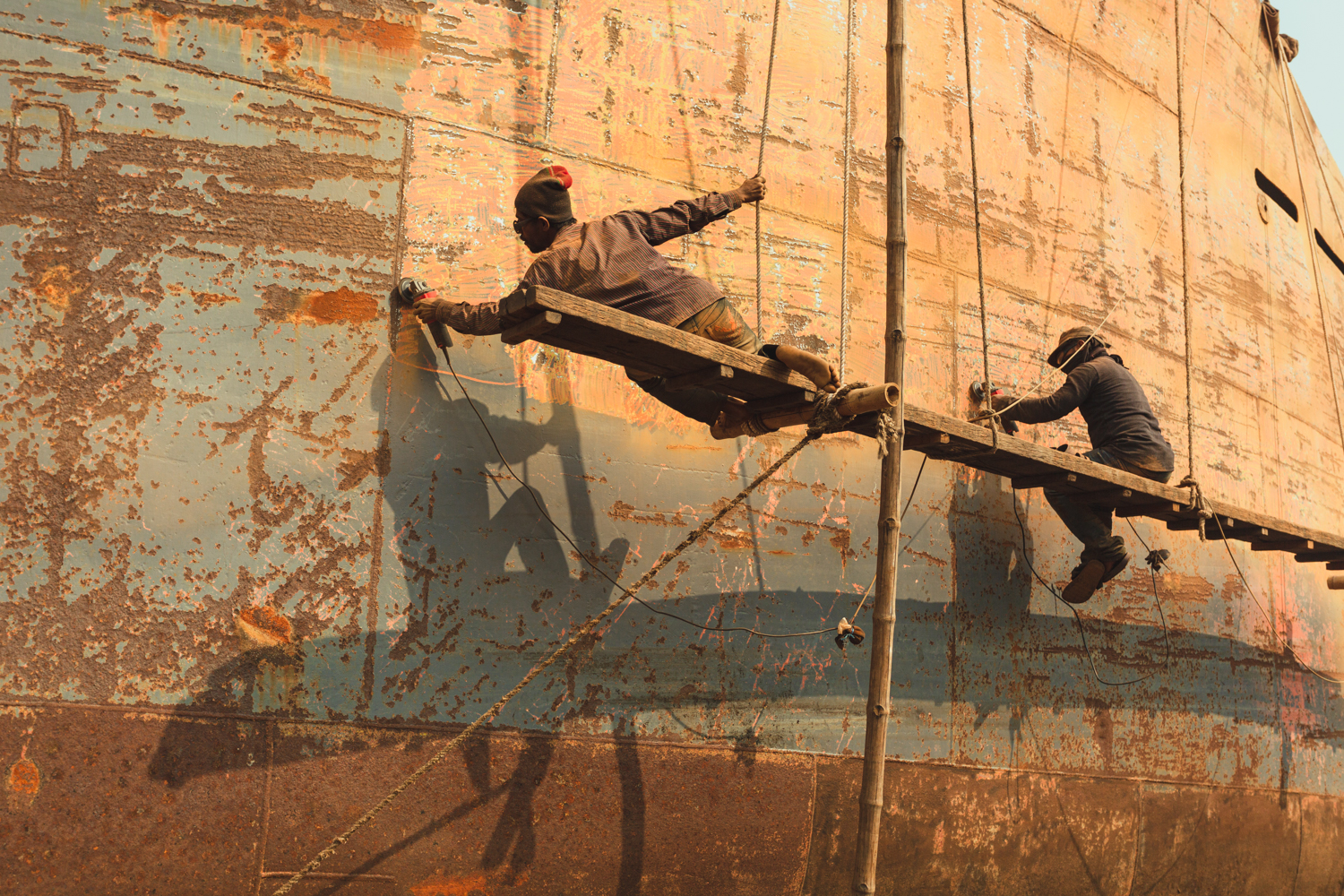 Hanging precariously off platform during repairs at Dhaka, Bangladesh Shipyard.