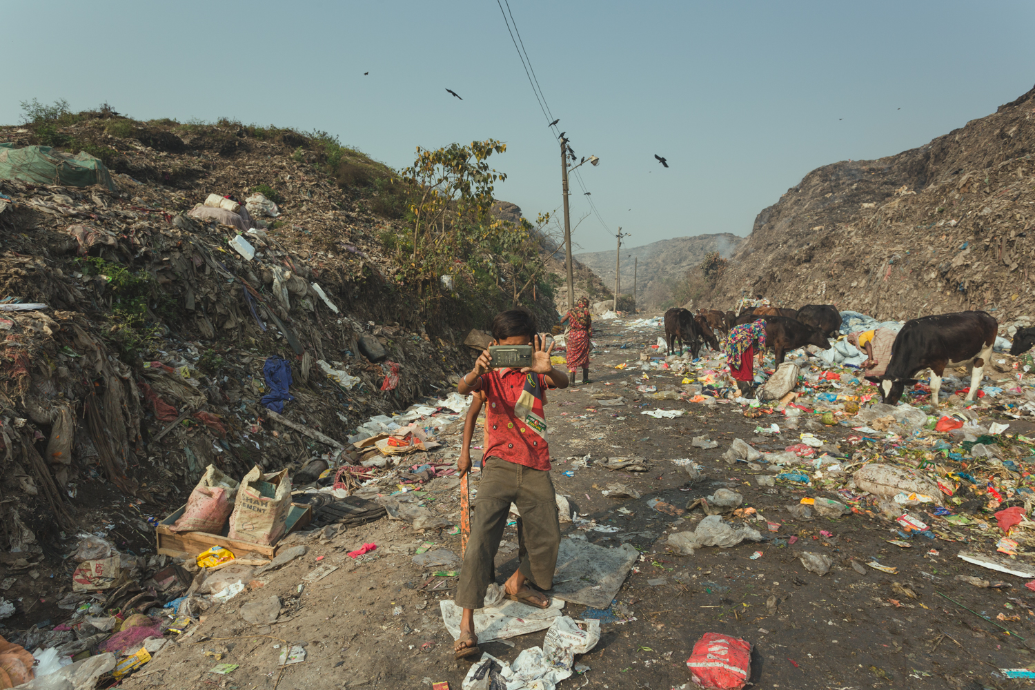 Boy of the Waste Picker community takes a photograph in Chittagong, Bangladesh.