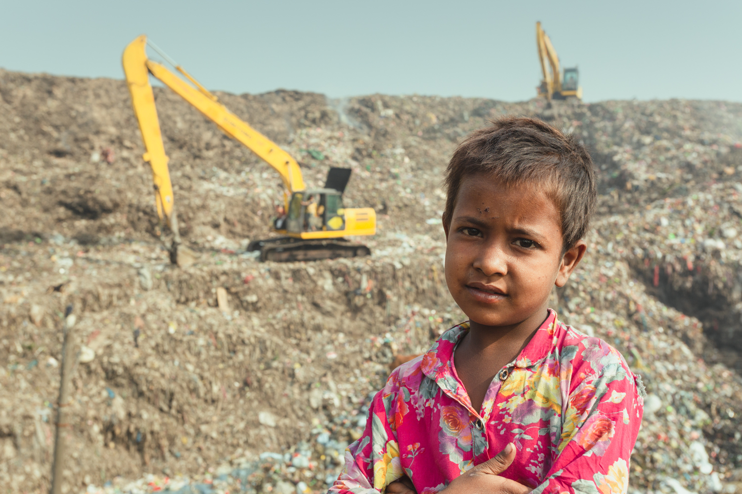 Young child in front of rubbish and equipment in Chittagong, Bangladesh.