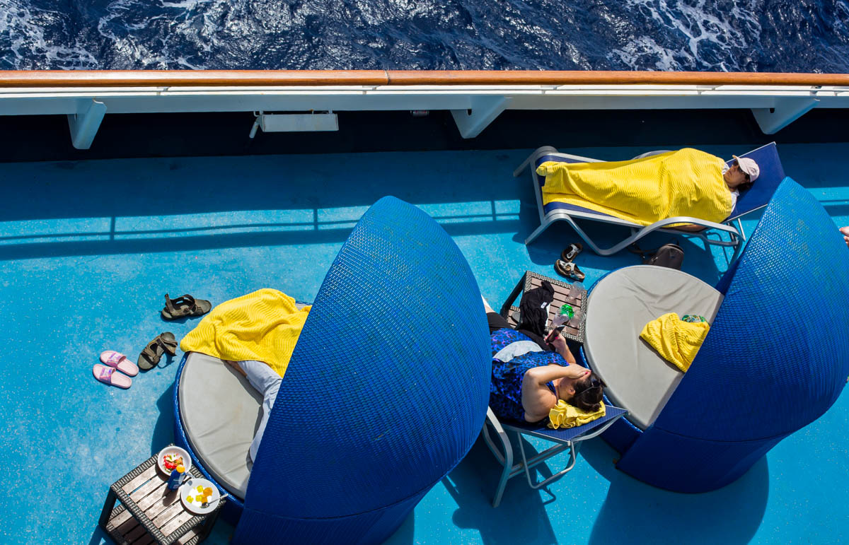 Women lying on deck chairs on cruise ship